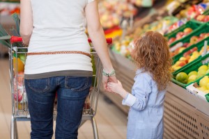 Mother holding her kids hand in supermarket